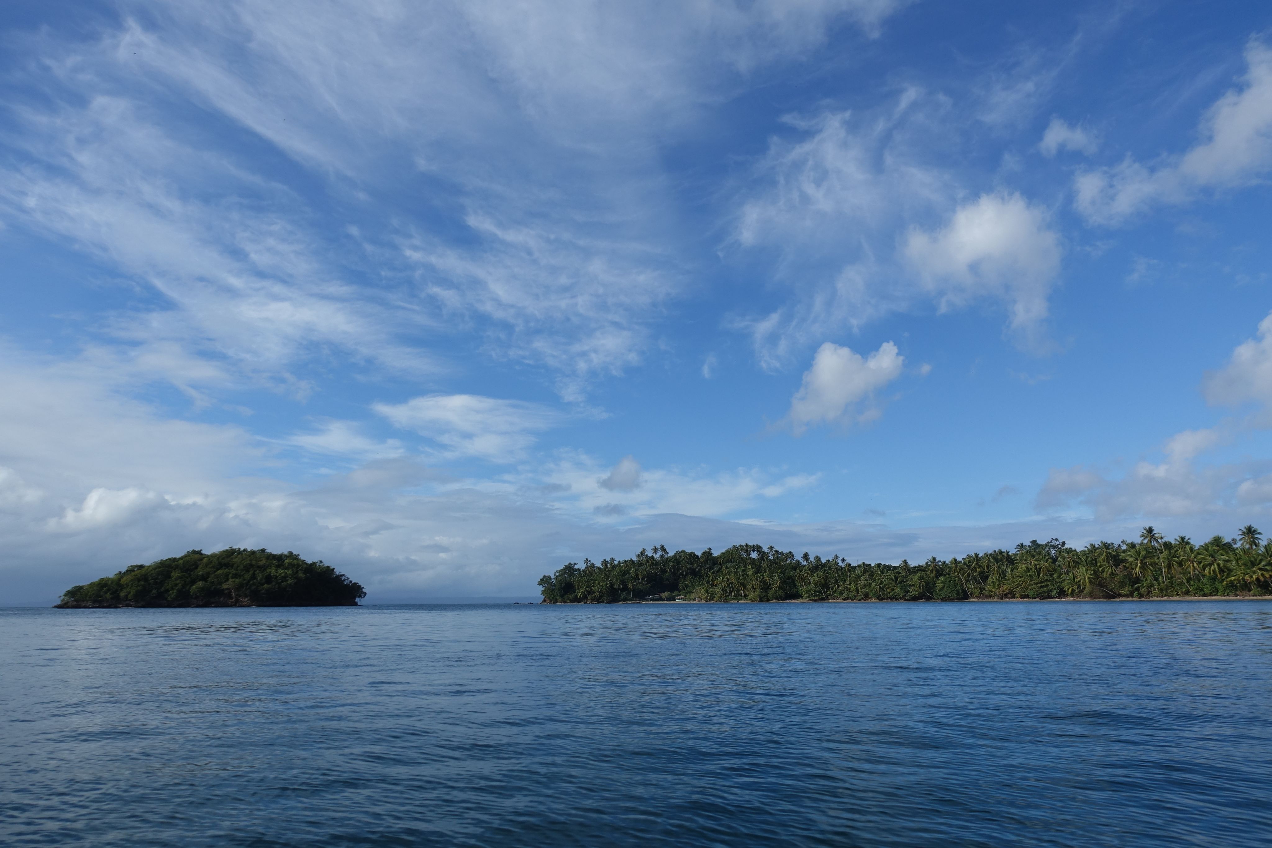 Sandy dunes with distant mountains under a hazy sky