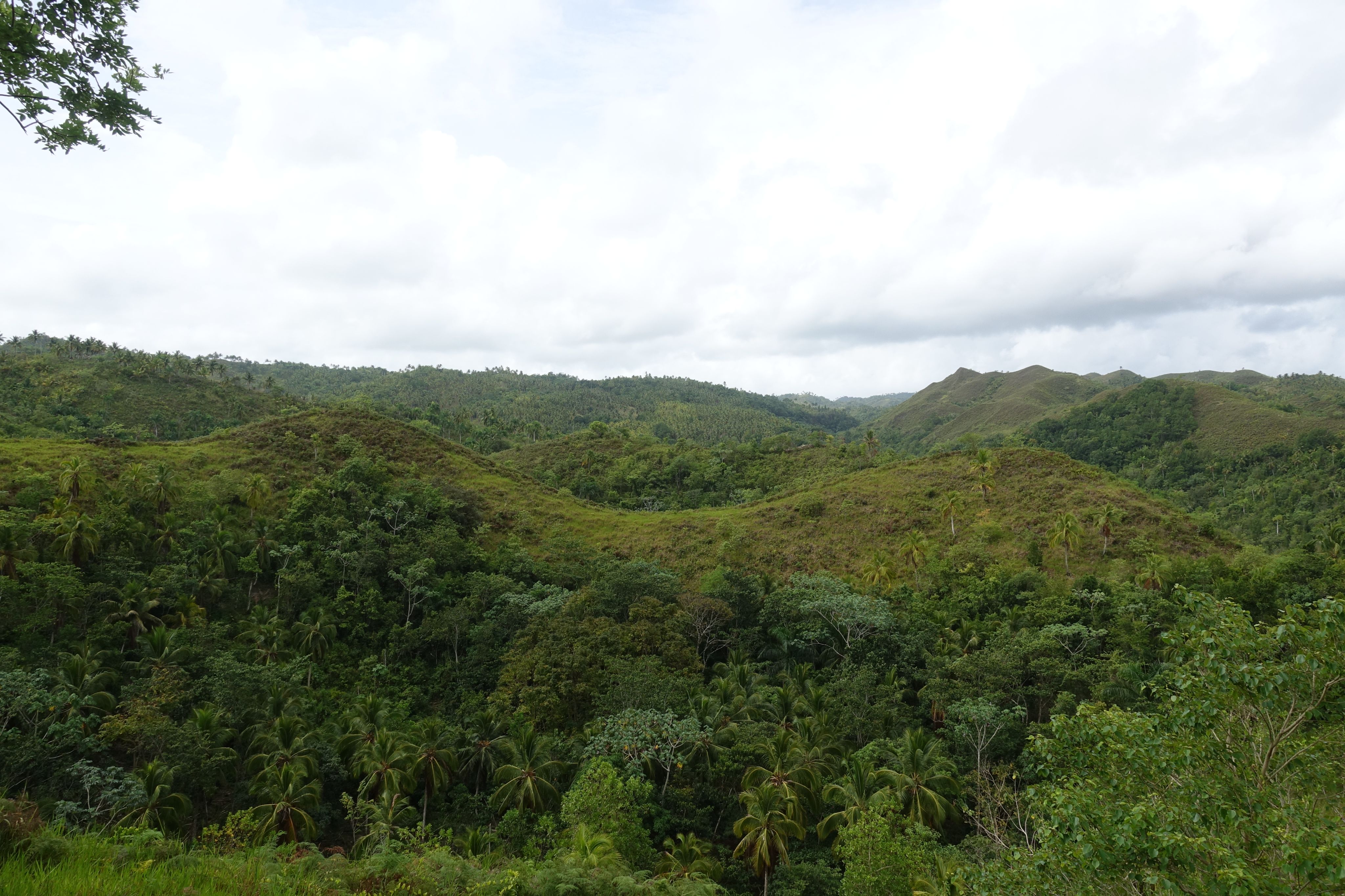 Sandy dunes with distant mountains under a hazy sky